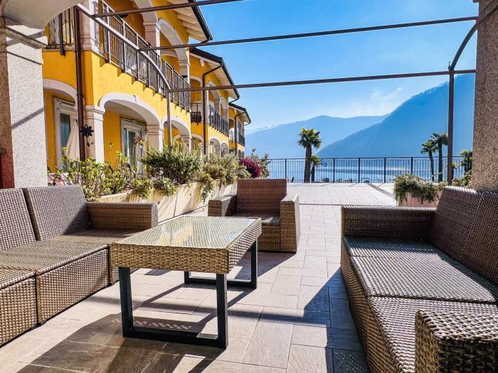 Eine ca. 100 m² große, teils überdachte Terrasse mit herrlichem Panoramablick auf den See, die umliegenden Berge und den gepflegten Palmengarten